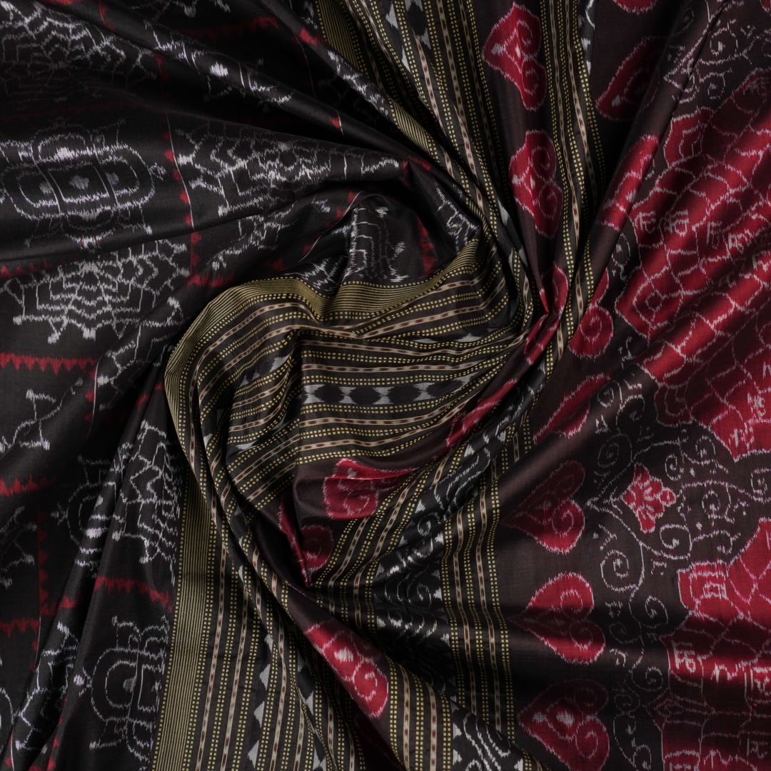 Extreme close-up of black Sambalpuri silk saree fabric, highlighting its luxurious texture and weave.
