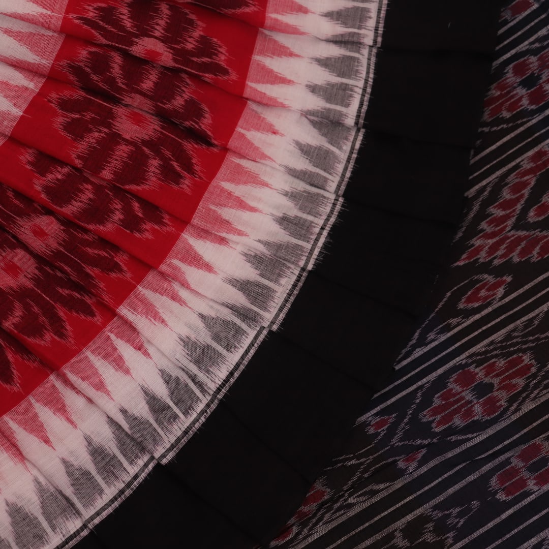 Saree styling: A red and black Sambalpuri cotton handloom saree with motifs is beautifully draped.