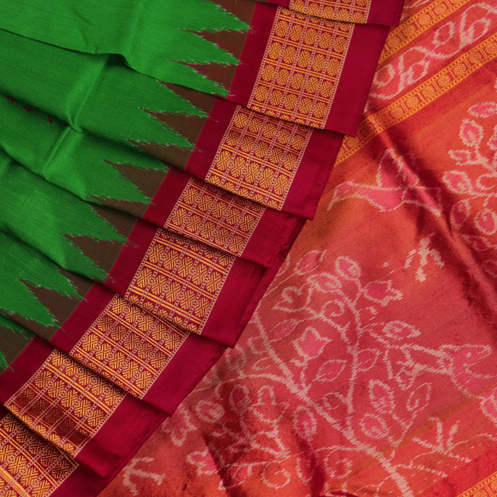 Close-up of luxurious green silk tissue saree fabric, showcasing intricate butta weaving details.