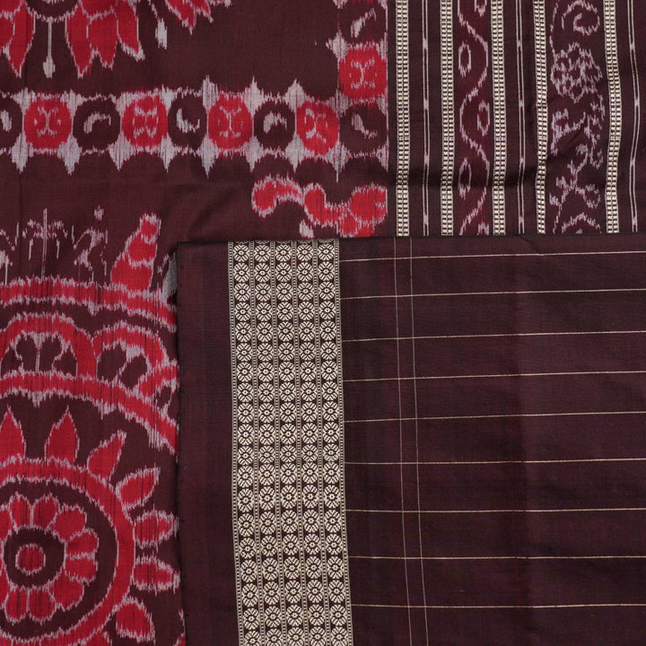 Ultra close-up of the red Sambalpuri silk saree fabric, revealing its luxurious texture and handloom weave.