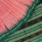 Close-up of the plain woven silk texture of a pink and green Sambalpuri saree.