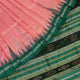 Close-up of the plain woven silk texture of a pink and green Sambalpuri saree.