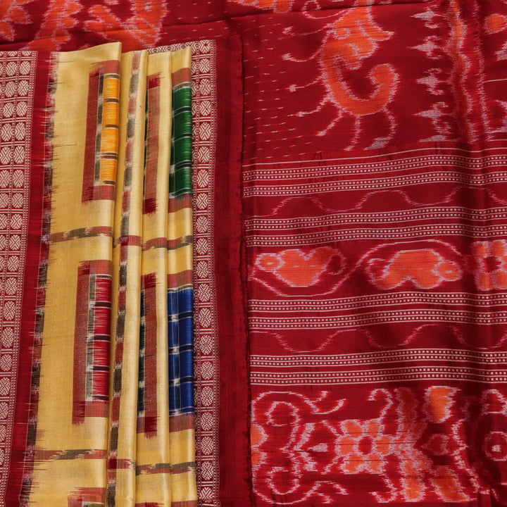 Close-up of multicolored Sambalpuri silk saree fabric texture showing intricate weave and maroon accents.