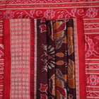 Close-up of the maroon Sambalpuri silk saree fabric, highlighting its luxurious texture and intricate weave.