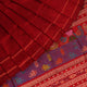 Close-up of maroon plain Sambalpuri silk saree fabric texture.