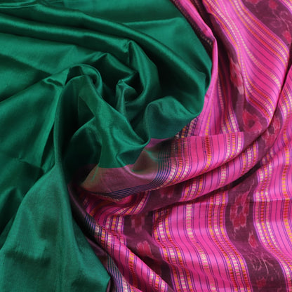Close-up of plain green and pink Sambalpuri silk saree fabric texture.