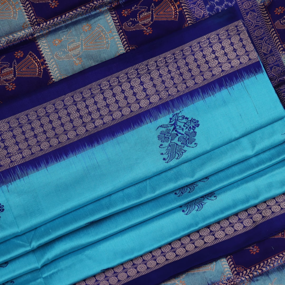 Close-up showcasing the silk texture of a blue and blue Bomkai silk saree with a butta pattern.