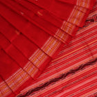 Close-up of the distinct handwoven texture of a red Sambalpuri silk saree with Butta pattern.