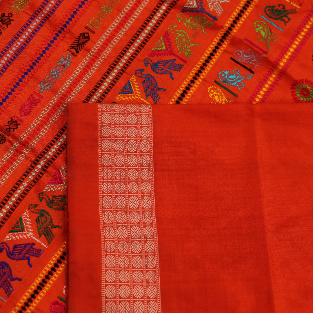 Close-up of finely woven silk fabric featuring intricate Butta patterns in multicolor with an orange accent