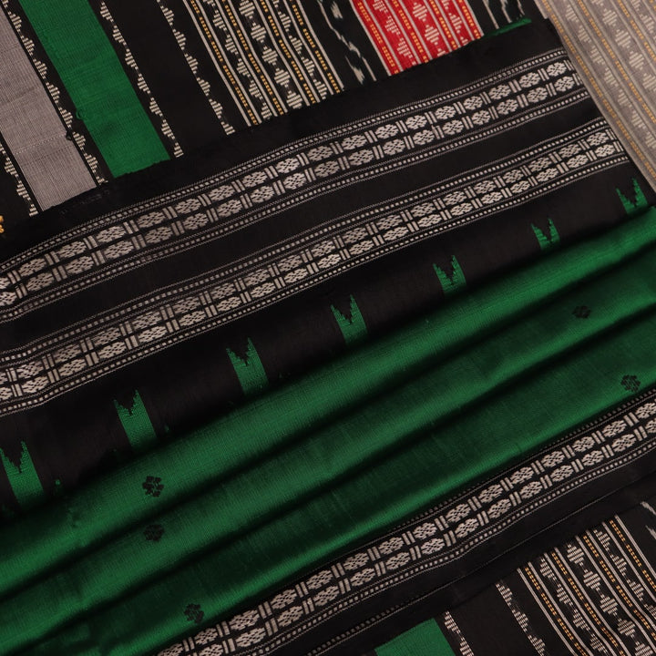 A close-up view of the lush, green silk fabric with a black butta pattern woven in.