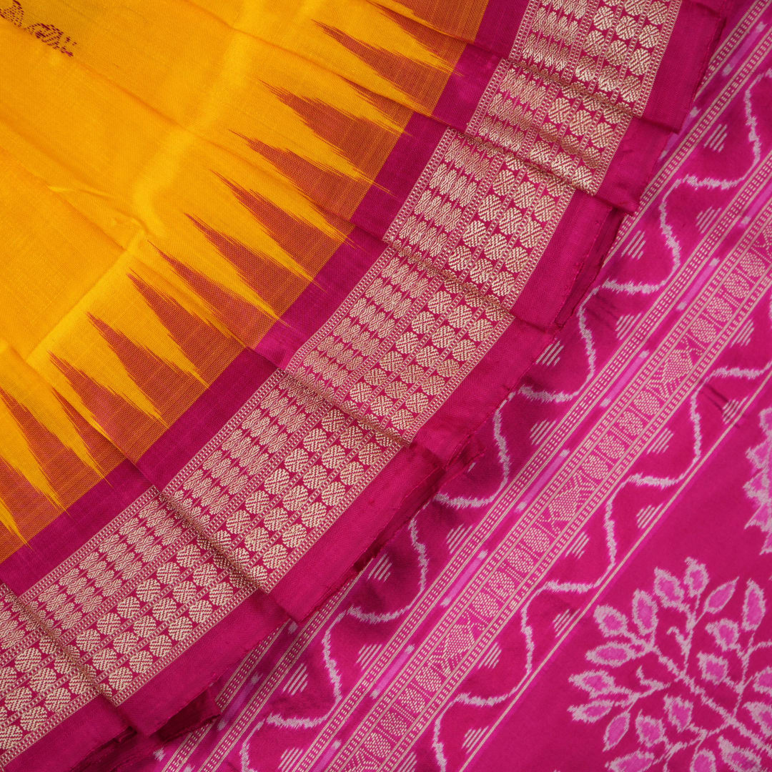 Close-up of the Bomkai Silk Saree's yellow fabric, revealing its luxurious texture and handloom weave.