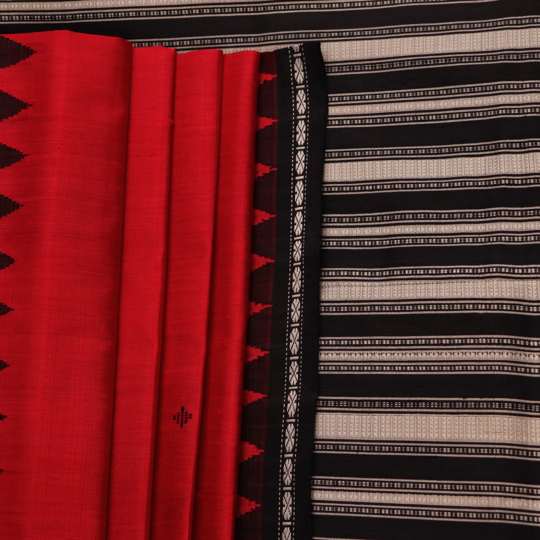 Close-up of the red and black plain silk fabric texture of a Berhampuri saree