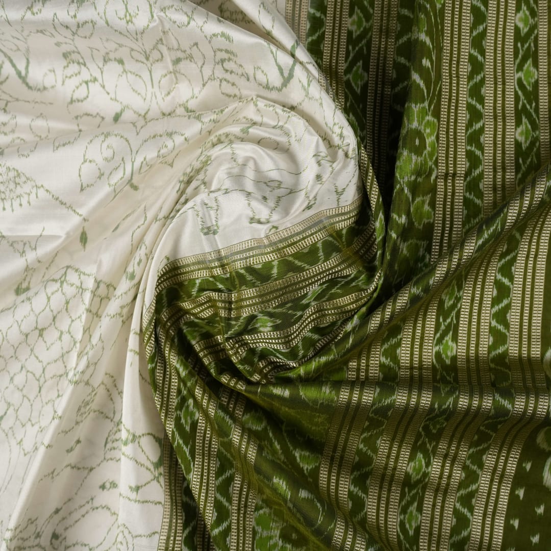 Close-up of the luxurious texture of the white Sambalpuri Silk Saree, revealing the fine weave and motif details.