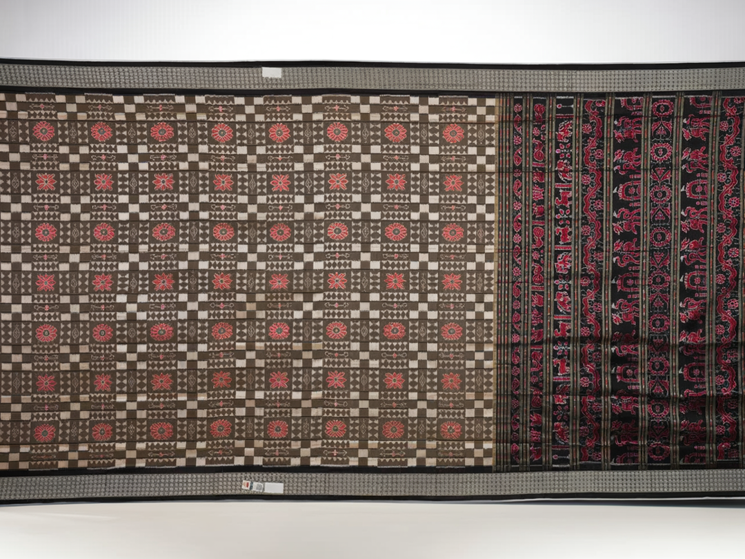 Close-up of the luxurious silk fabric texture and handloom weave of the grey and black Sambalpuri saree.