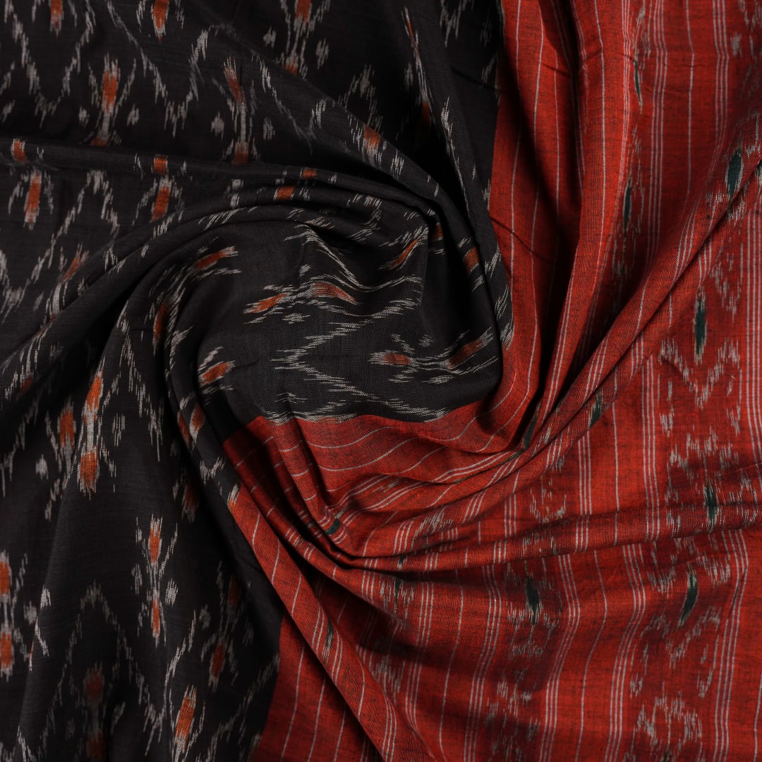 Elegant model styling of a black and orange Sambalpuri cotton saree showcasing the complete handloom look.