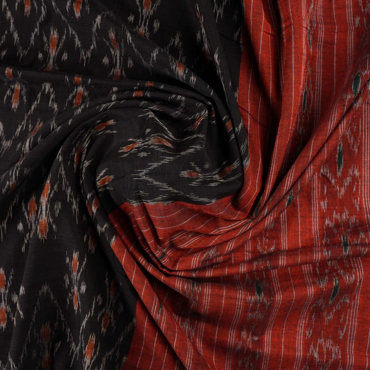 Elegant model styling of a black and orange Sambalpuri cotton saree showcasing the complete handloom look.