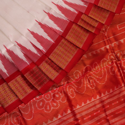 Close-up of white and red silk Bomkai saree fabric texture with butta pattern.