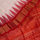 Close-up of white and red silk Bomkai saree fabric texture with butta pattern.