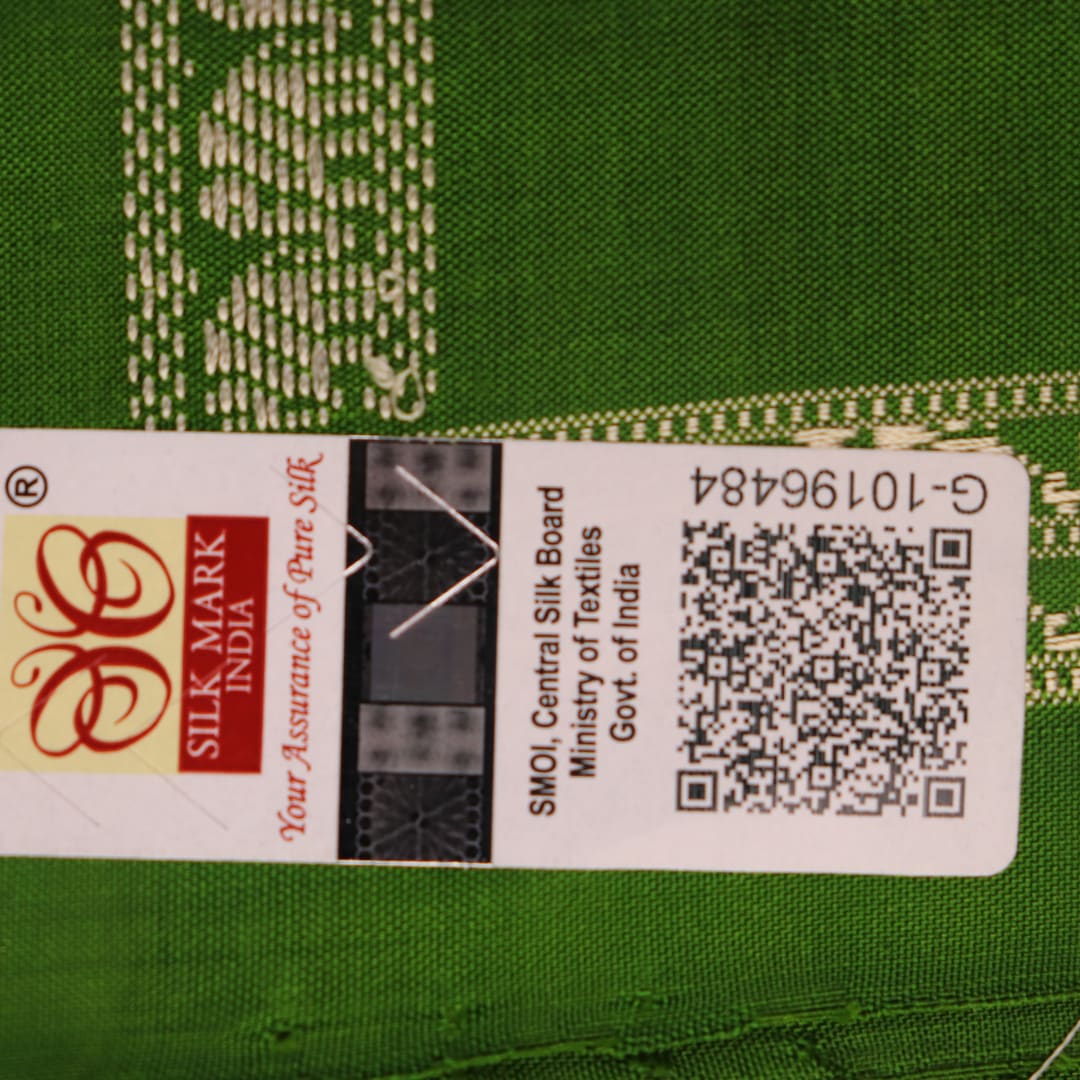 Close-up of cream and green Bomkai Silk Saree fabric texture with butta pattern.