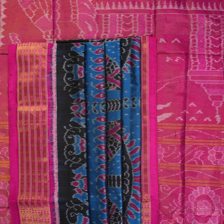 Close-up revealing the sheer tissue silk texture of the black saree, with subtle shimmering pink motifs.