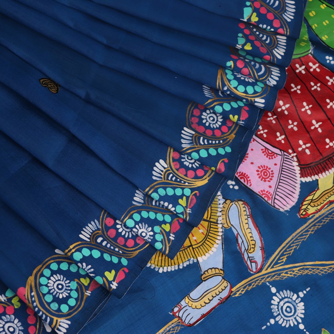 Close-up of handloom blue silk Patachitra saree fabric, showcasing the fine texture and hand-painted details.