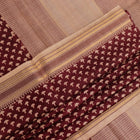 Close-up of maroon Tussar silk saree fabric, showing natural slub texture and printed pattern.