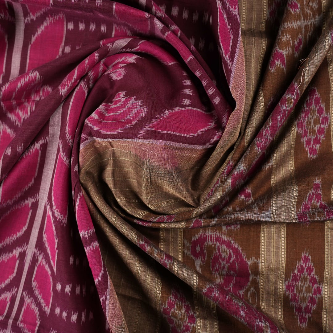 Model wearing an elegantly draped maroon and brown Sambalpuri cotton saree with traditional ikat motifs.