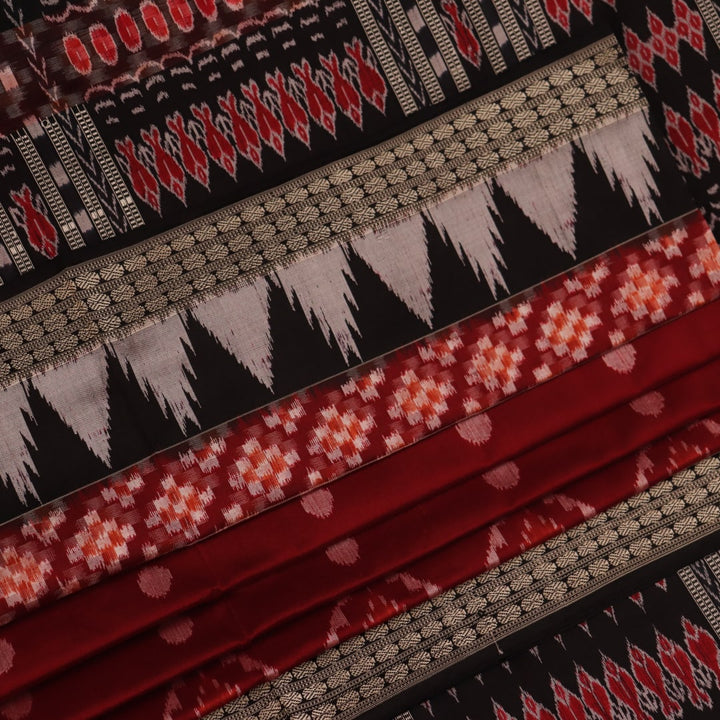 Close-up view of maroon and black silk Sambalpuri saree fabric showcasing intricate motifs