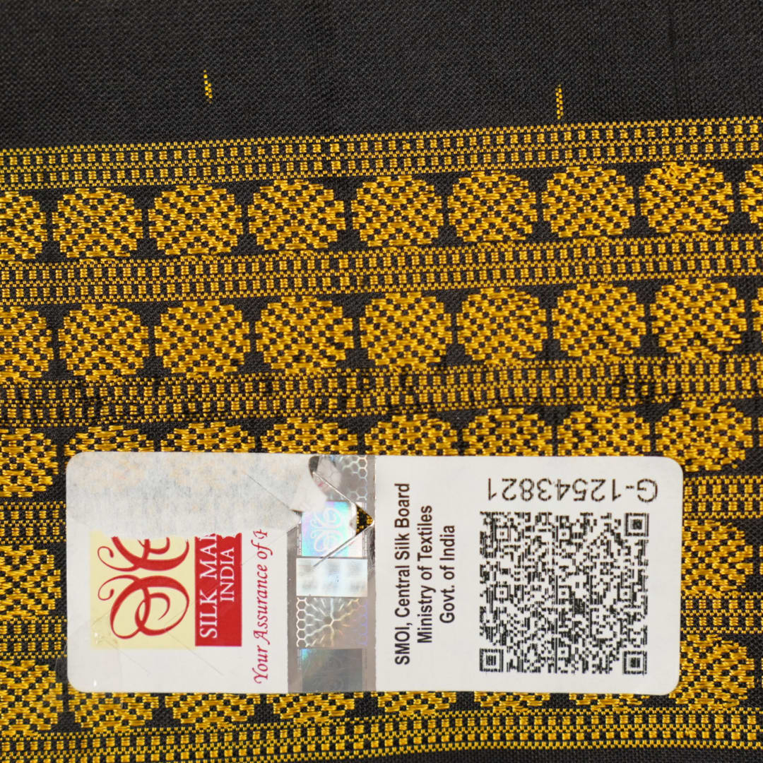Close-up of the black Sambalpuri silk saree fabric, revealing its rich texture and the intricate weave of the motifs.