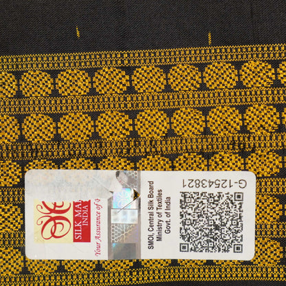 Close-up of the black Sambalpuri silk saree fabric, revealing its rich texture and the intricate weave of the motifs.