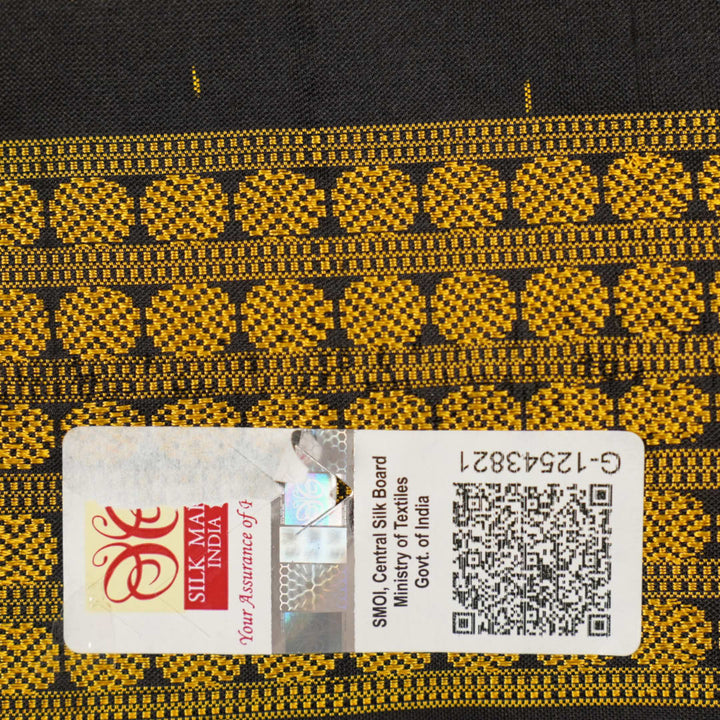 Close-up of the black Sambalpuri silk saree fabric, revealing its rich texture and the intricate weave of the motifs.