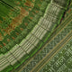 Ultra close-up of green Sambalpuri silk fabric, revealing its unique texture and fine weave.