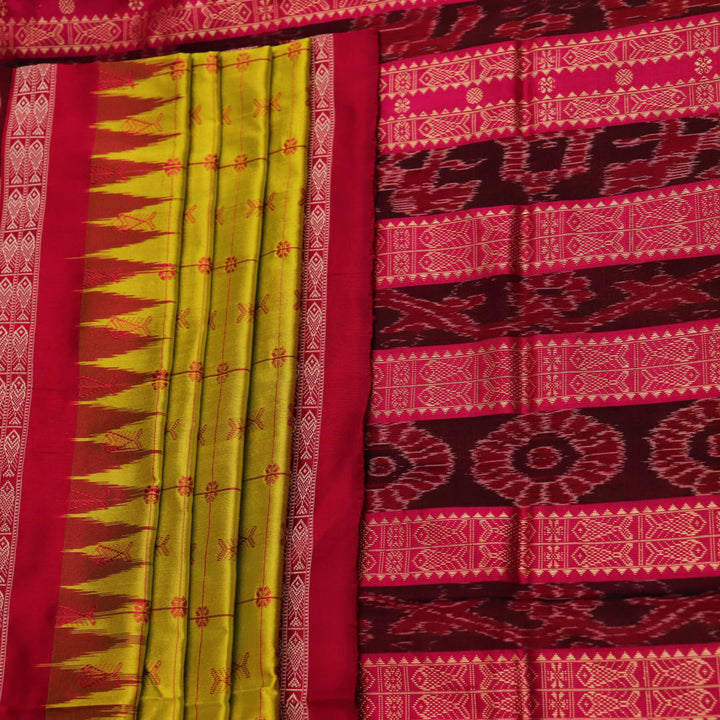 Close-up view of the soft silk fabric texture of a green and magenta Sambalpuri saree with intricate butta patterns