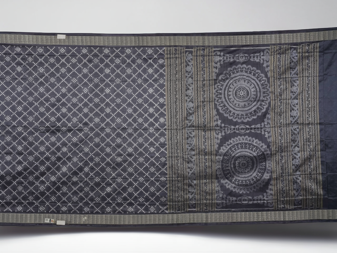 Close-up of the soft, luxurious grey Sambalpuri silk fabric texture with subtle weave details.