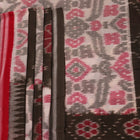 Off-white Sambalpuri cotton saree with green motifs, elegantly draped.