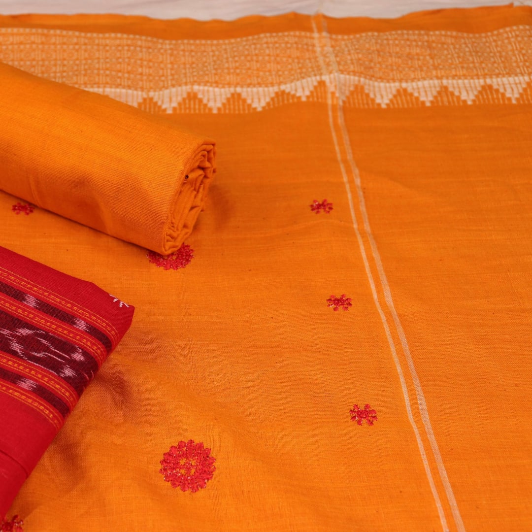 Close-up view of a red and yellow cotton Sambalpuri dress material with intricate motif patterns