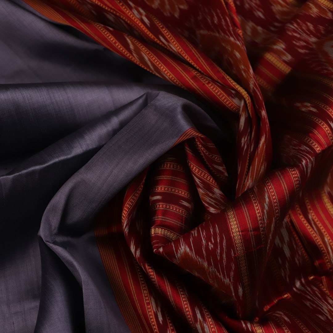 Grey Khandua silk saree styled and draped, showcasing the plain body and red border.