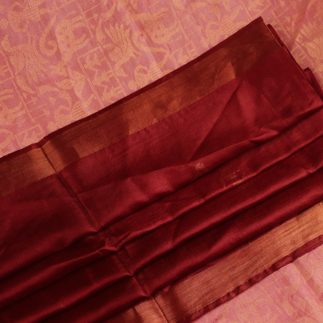 Close-up of intricate butta pattern woven on Tussar silk fabric in a maroon hue