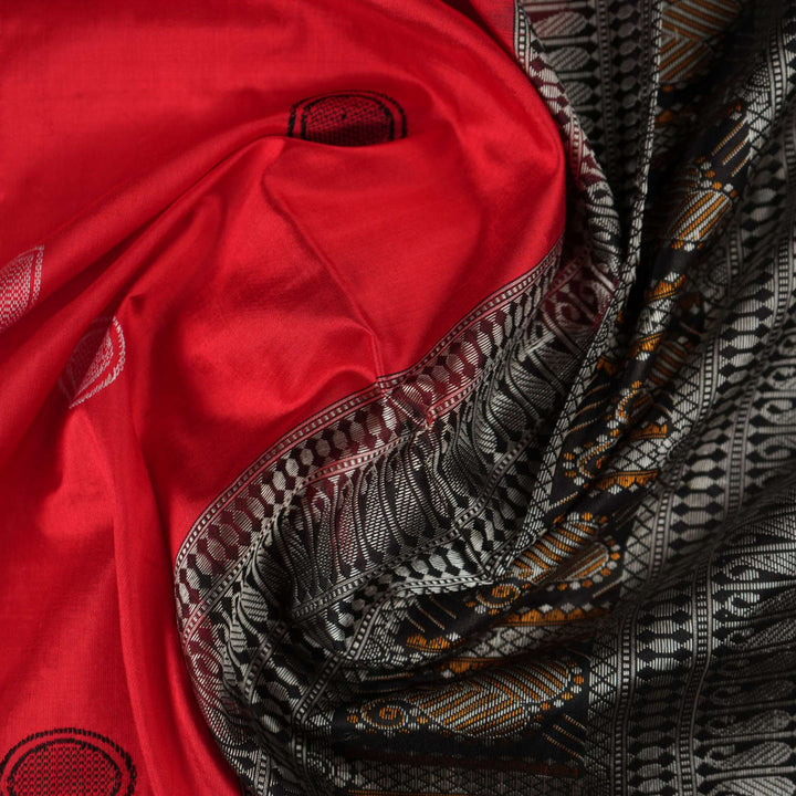 Extreme close-up of red Bomkai silk saree fabric showcasing rich texture and intricate weave.