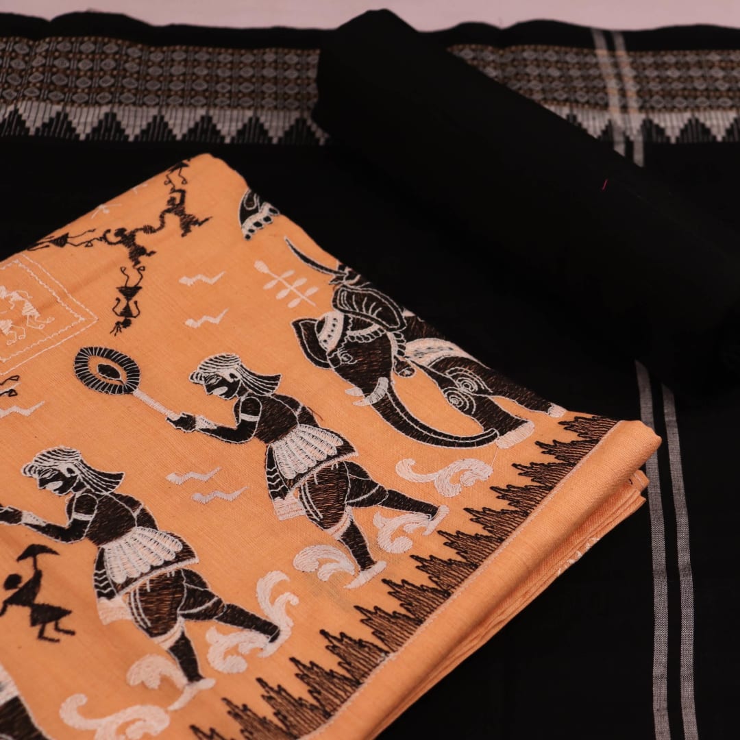 Detailed view of a Sambalpuri cotton dress material in brown and black, showcasing the doll-patterned design on the body.