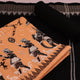 Detailed view of a Sambalpuri cotton dress material in brown and black, showcasing the doll-patterned design on the body.