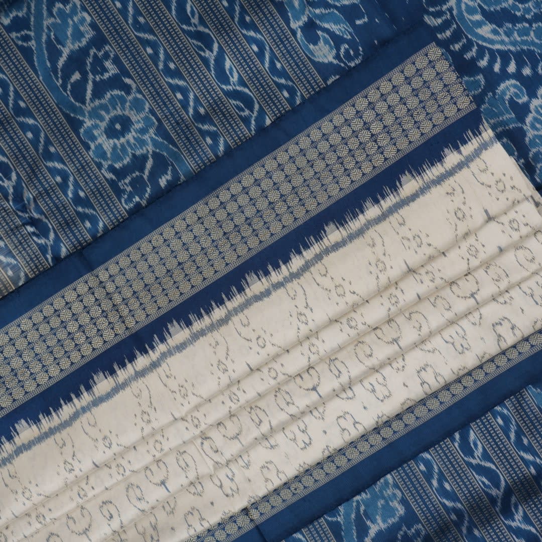 Close-up of premium fabric texture and handloom weave on a white and blue Sambalpuri silk saree