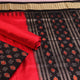 Detail of black Sambalpuri silk blouse piece from dress material, featuring red motifs.