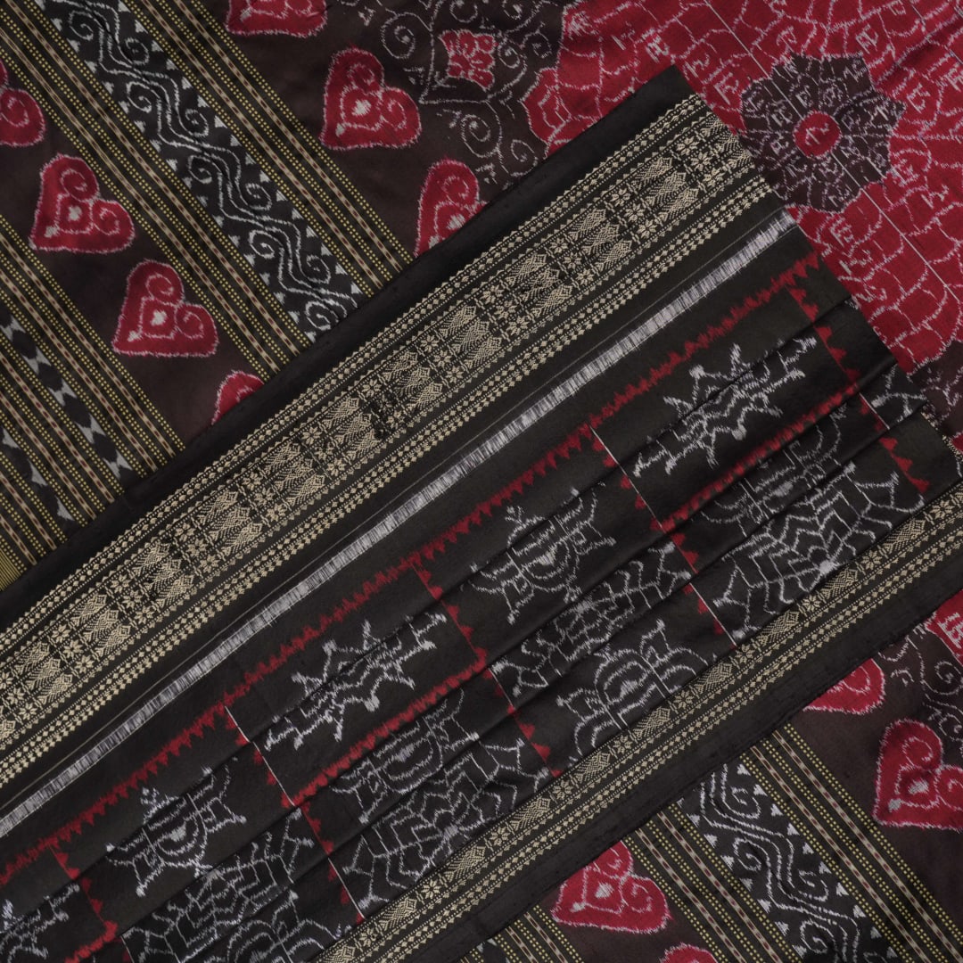 Extreme close-up of black Sambalpuri silk saree fabric, highlighting its luxurious texture and weave.