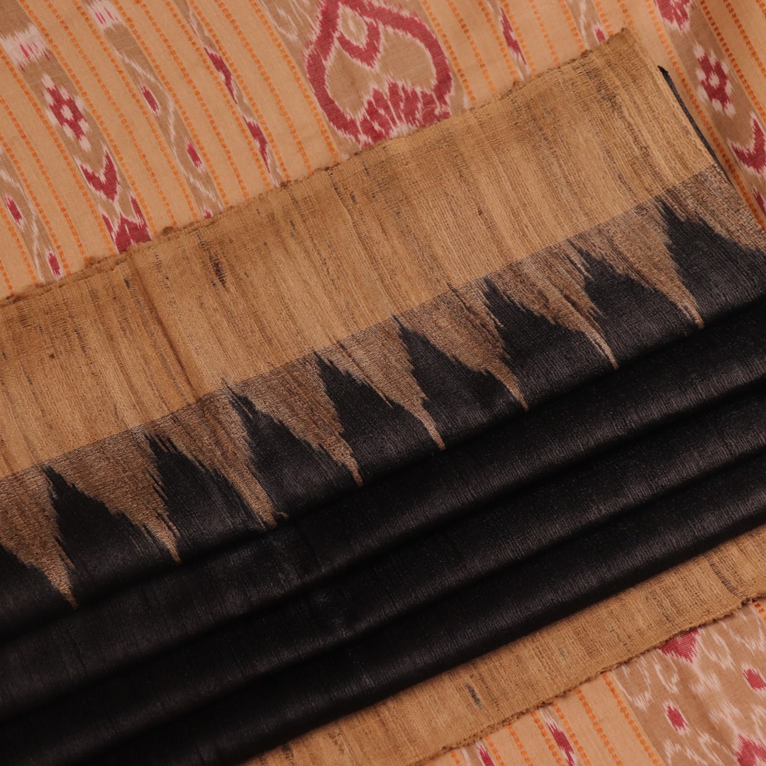 Close-up of black and cream tussar silk sari fabric showing the plain texture.