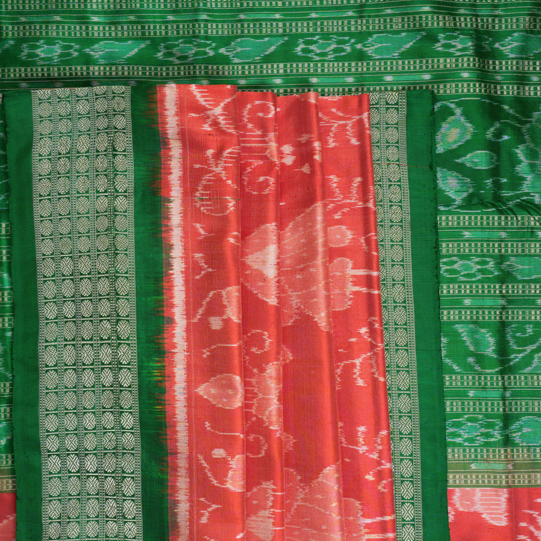 Close-up of the smooth, rich silk texture of the peach Sambalpuri saree with fine motifs.