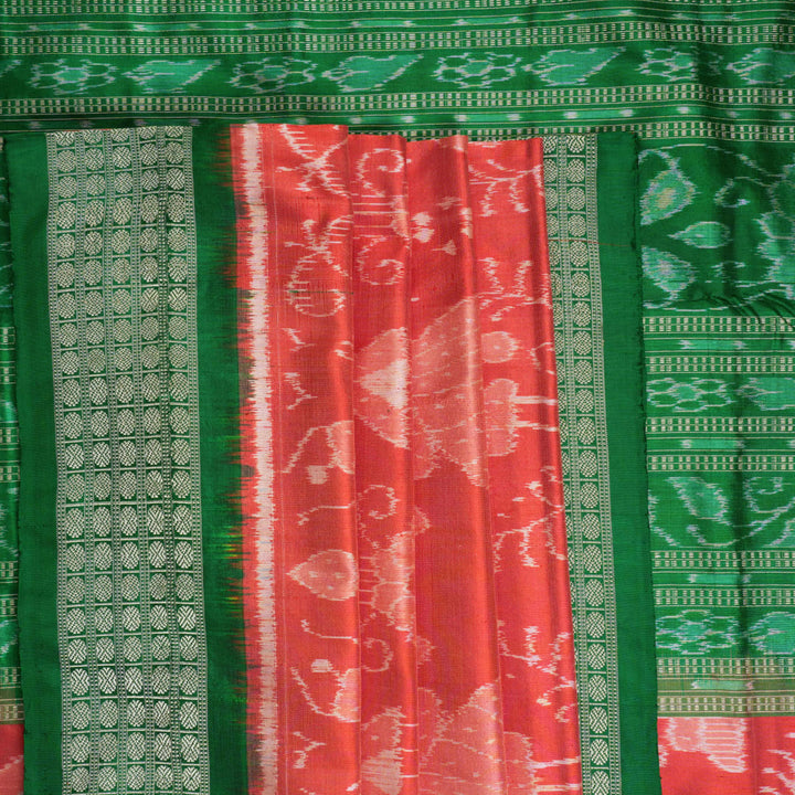 Close-up of the smooth, rich silk texture of the peach Sambalpuri saree with fine motifs.