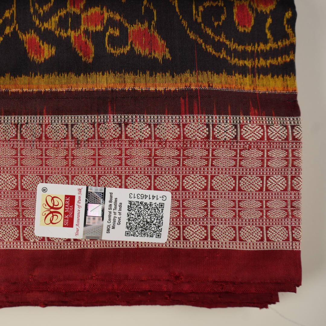 Close-up of Sambalpuri silk fabric texture, highlighting fine handloom weave in black and maroon.