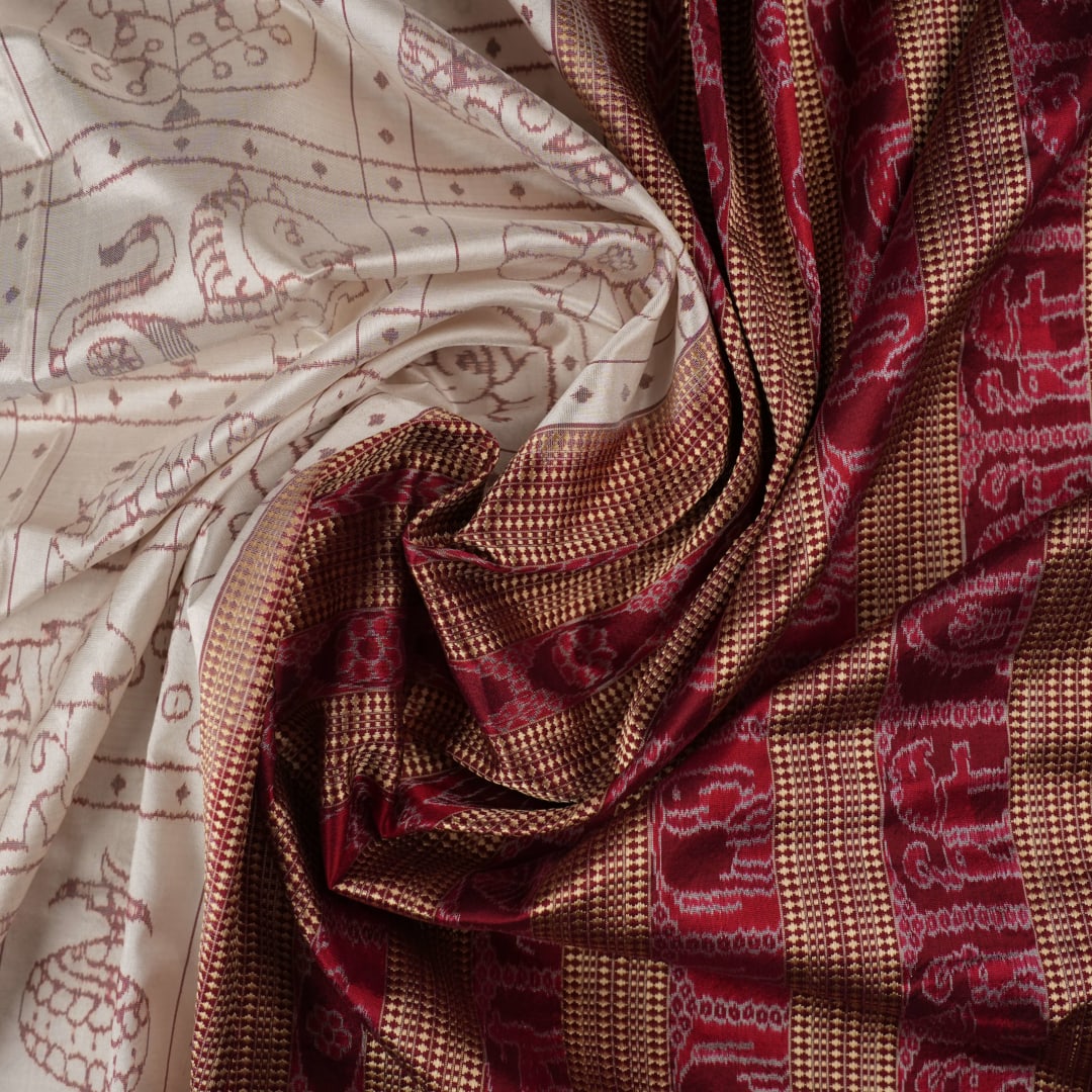 Close-up of the fine silk texture of the white Sambalpuri saree, highlighting its soft sheen and weave.