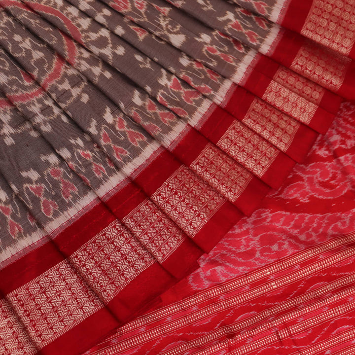 Close-up of grey Sambalpuri silk saree fabric showing intricate motif texture.